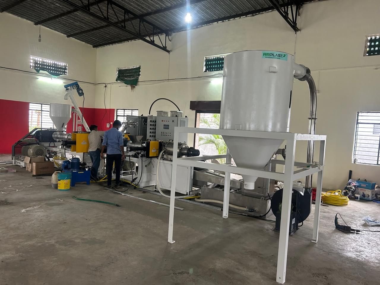 Gidiya Polytech engineers operating the extrusion control panel beside the dosing silo